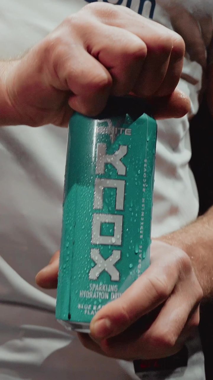 A hand opens a pink KNOX can